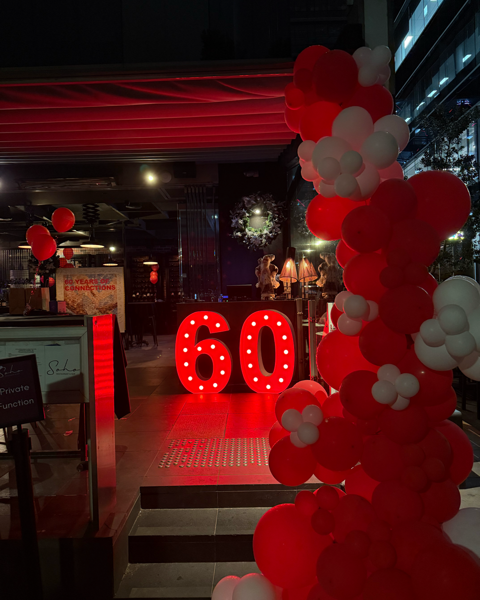 Decorative setup with red and white balloons and a large '60' sign in a festive setting.