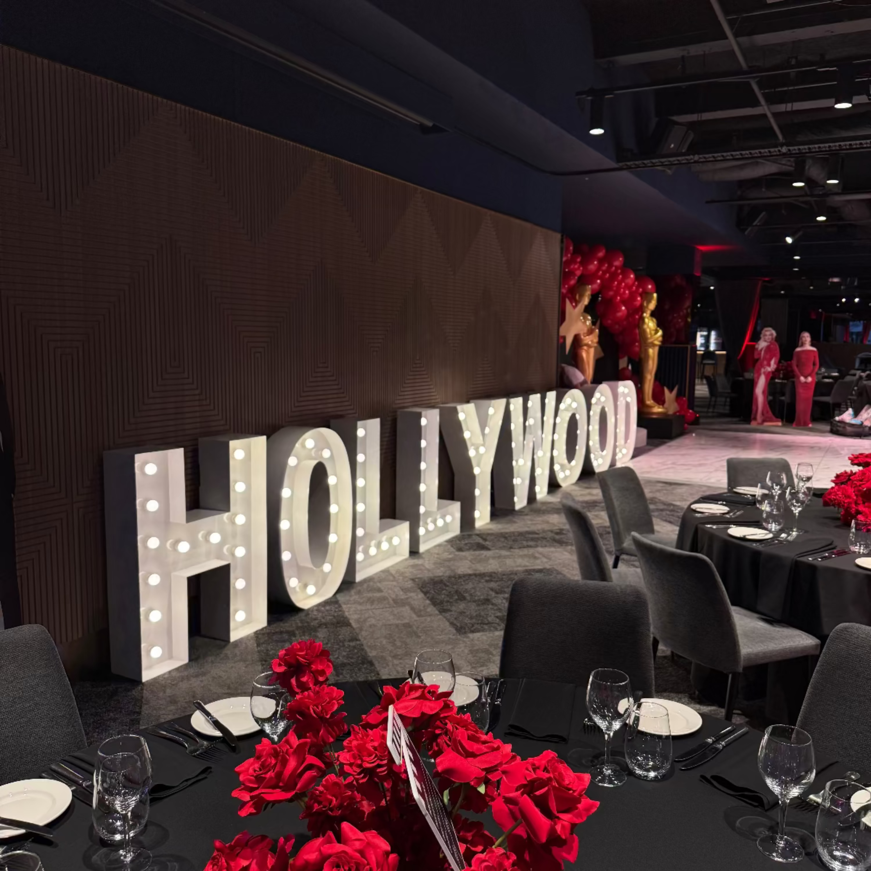 Decorative setup with 'Hollywood' sign and tables set for an event.