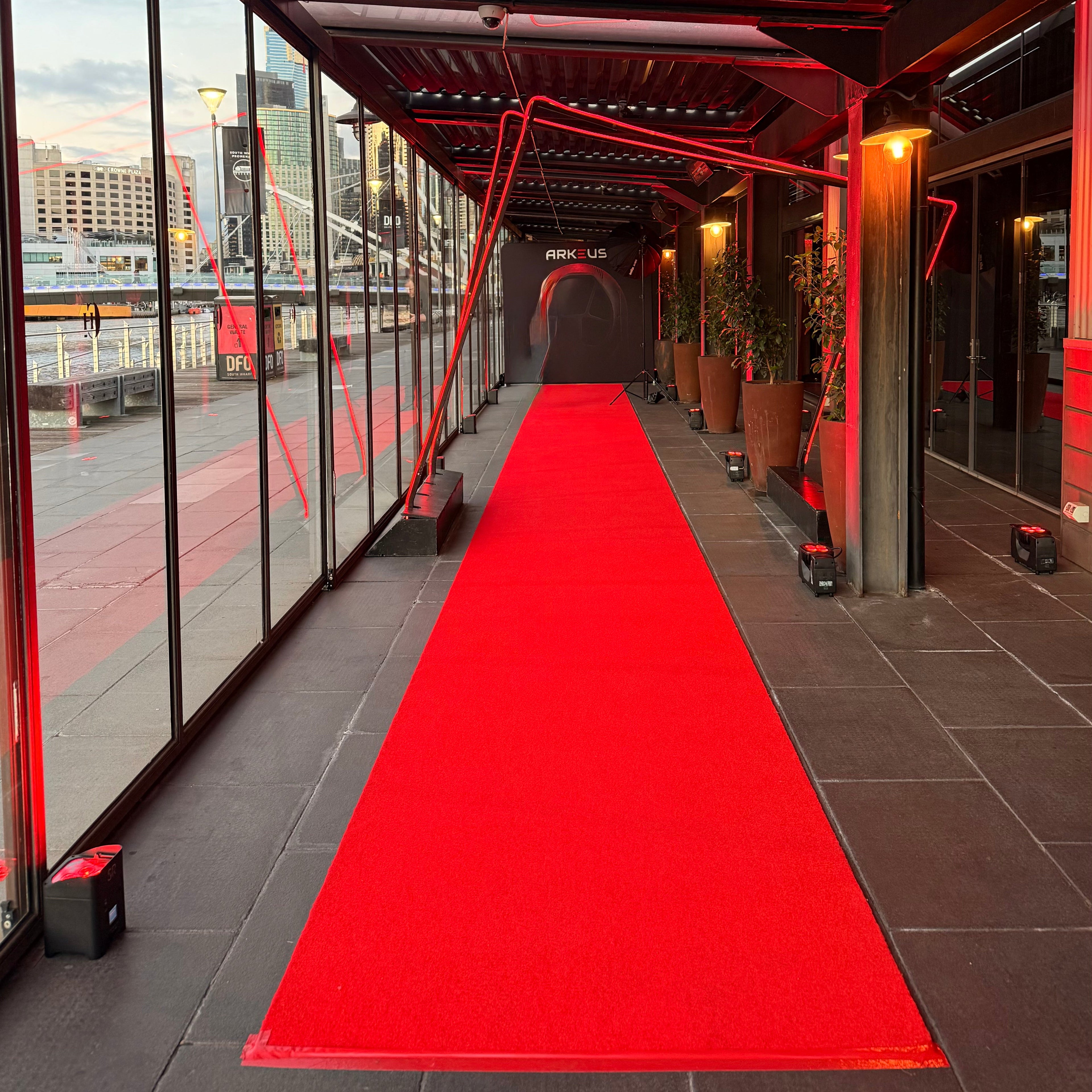 15m red carpet runner hire Melbourne with red uplighting and a custom media wall