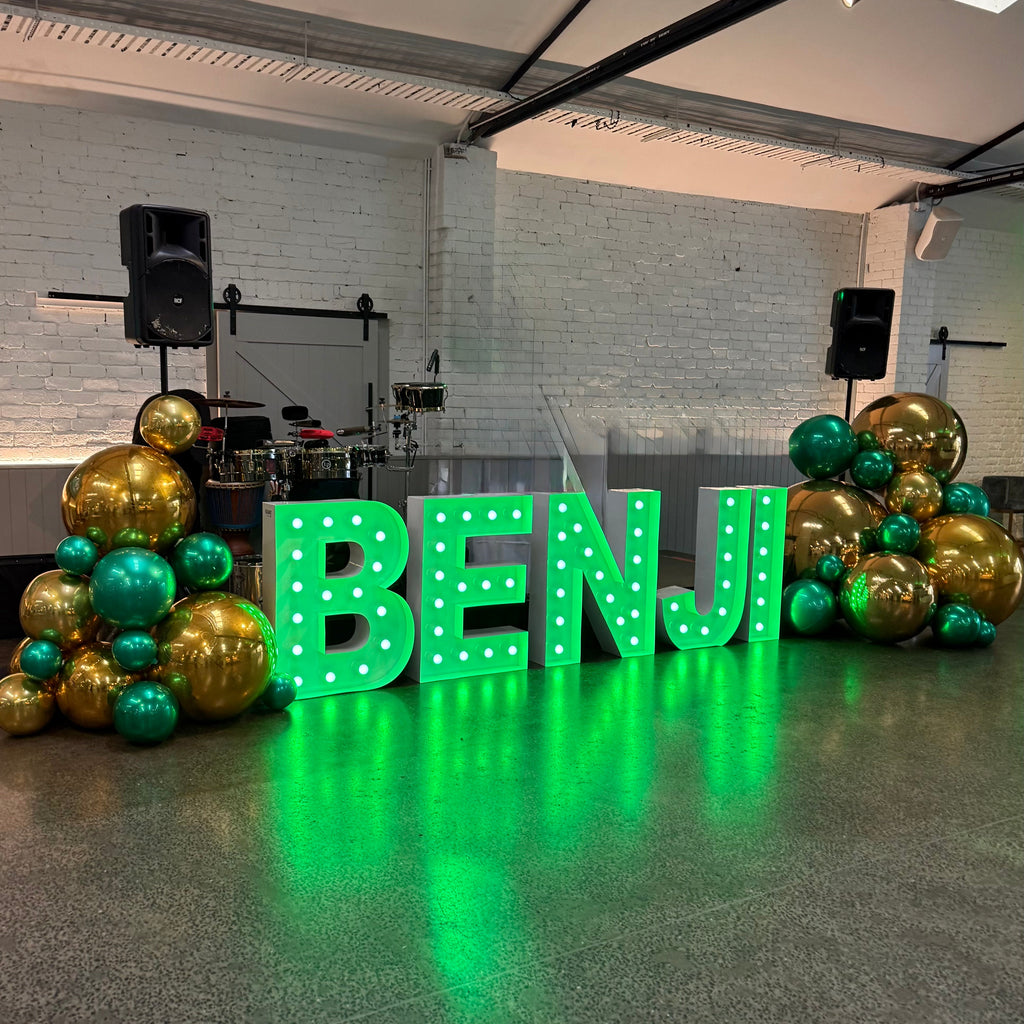 Green globes light up letters BENJI with gold ball balloons