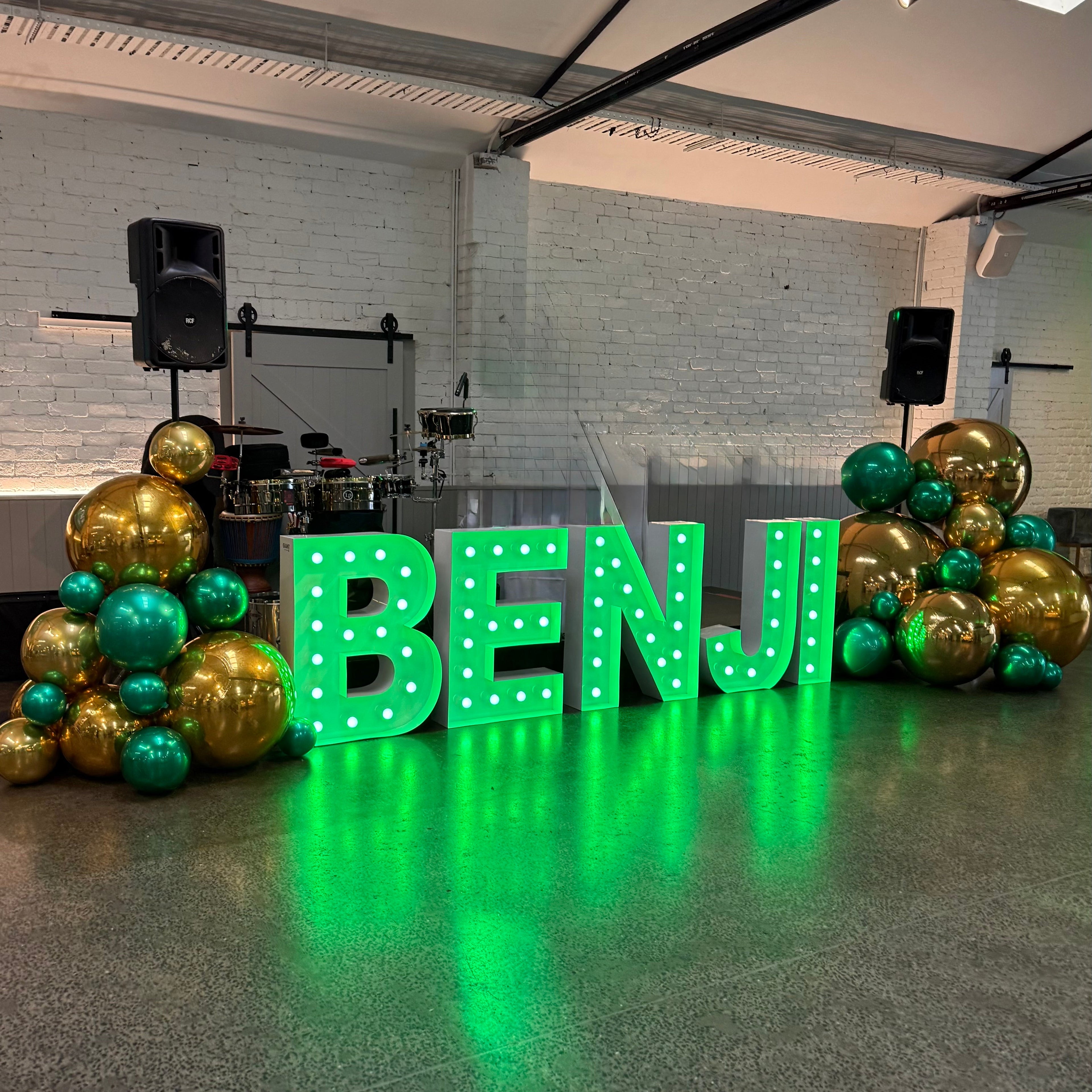 Green globes light up letters BENJI with gold ball balloons